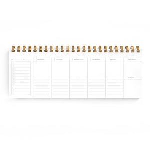 Planner page with white background and lines and black text says, "Monday, Tuesday, Wednesday, Thursday, Friday, Saturday, Sunday". Gold coil binding at top. 