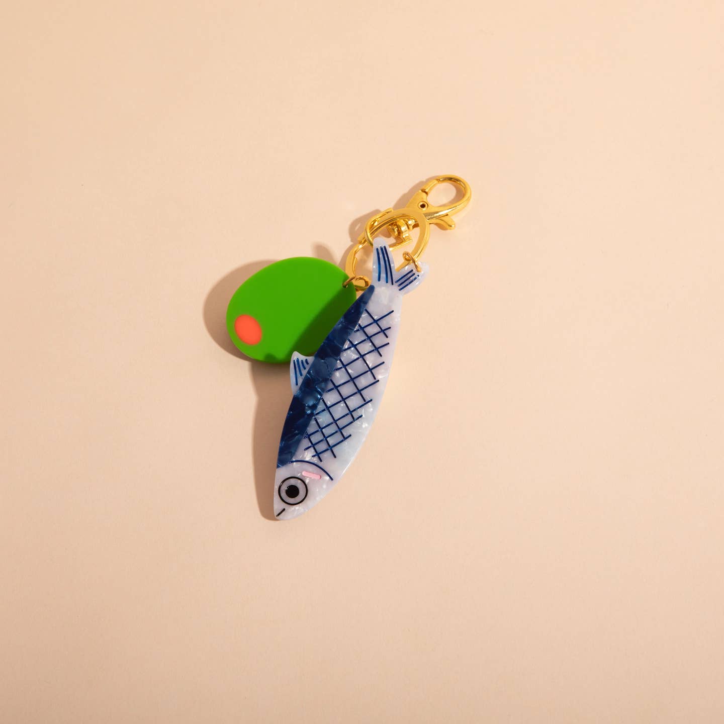 Image of a plastic charm in the shape of a green and red pimento olive and a blue and white anchovy with brass clasp.