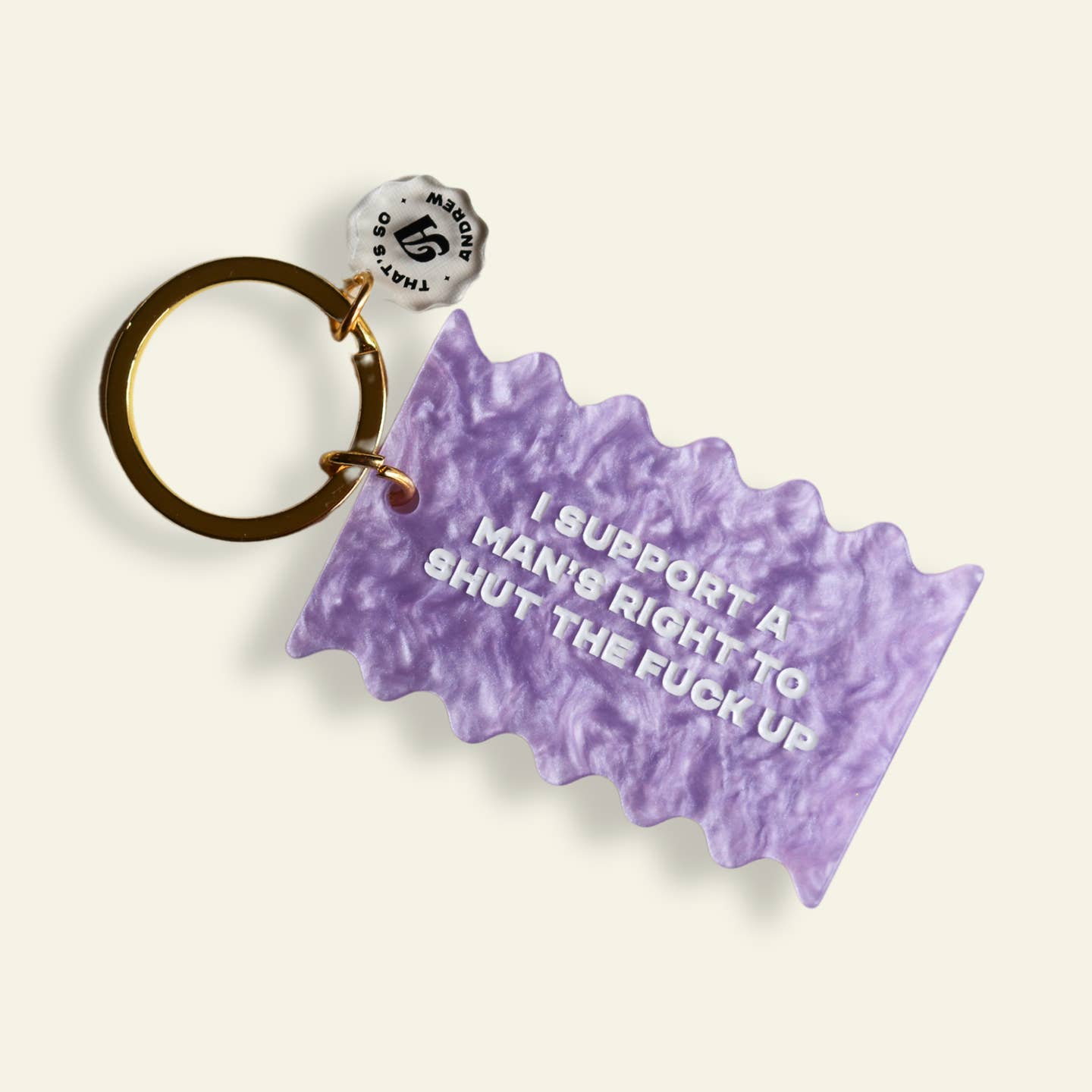 Image of a keychain with purple rectangle with white texts says, "I support a man's right to shut the fuck up". 