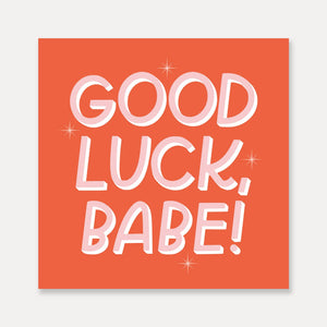 Decorative sticker with dark apricot background with pink and white text says, "Good luck, Babe!".