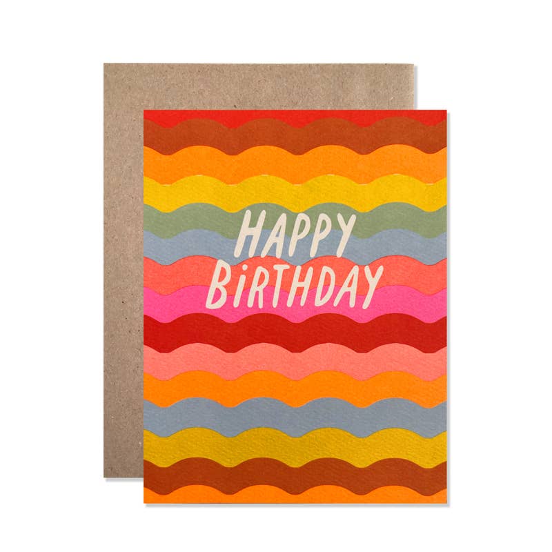 Greeting card with images of horizontal ricrac design in red, orange, yellow, green, blue, salmon, pink with white text says, "Happy birthday". Kraft envelope included. 
