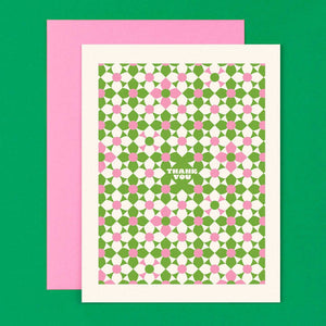 Greeting card with background of green, pink and white modern flowers with white text says, "Thank you" in center of card. Pink envelop included. 