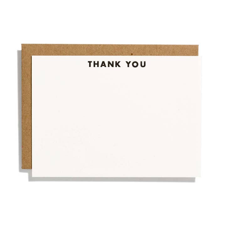 Ivory cards with black text says, " thank you" in top center of card with kraft envelopes. 