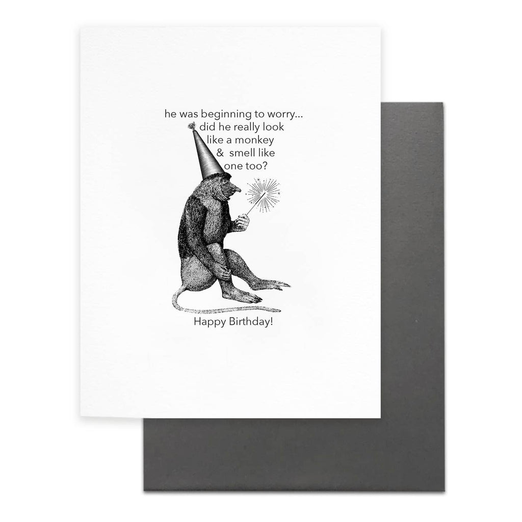 White background with grey text says, “he was beginning to worry…did he really look like a money & small like one too? Happy birthday” with image of a monkey in a party hat holding a sparkler. Grey envelope is included. 
