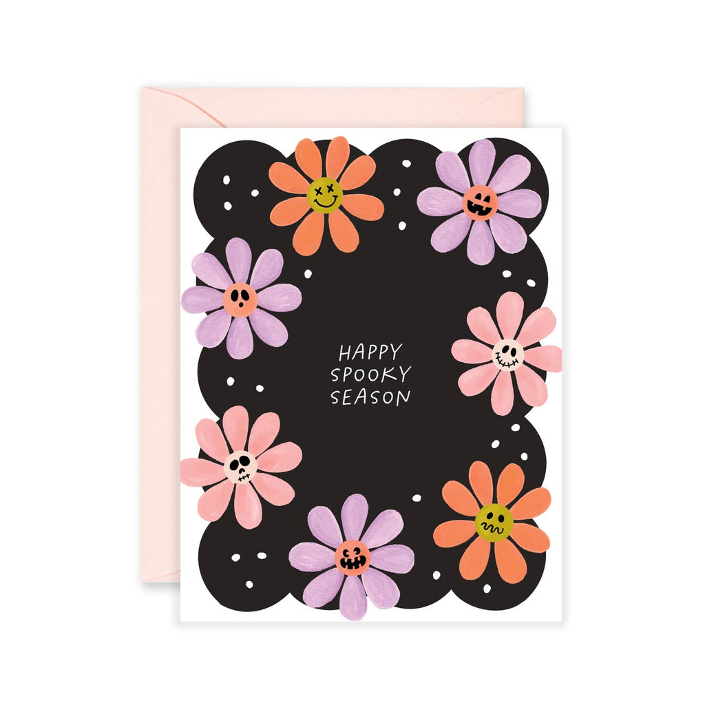 White and black background with images of flowers with centers  that are ghosts, skulls and pumpkins with grey text says, "Happy spooky season". Pink envelope included. 
