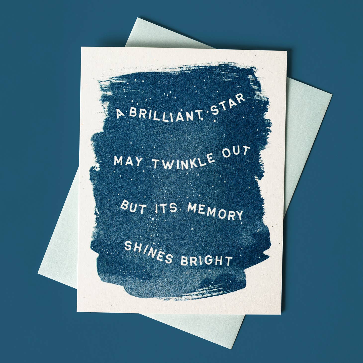 White background with dark blue center and white text says, "A brilliant star may twinkle out but its memory shines bright". Pale blue envelope is included. 
