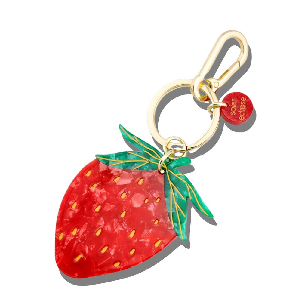 Image of keychain charm in shape of red strawberry with gold colored key ring and clip. 