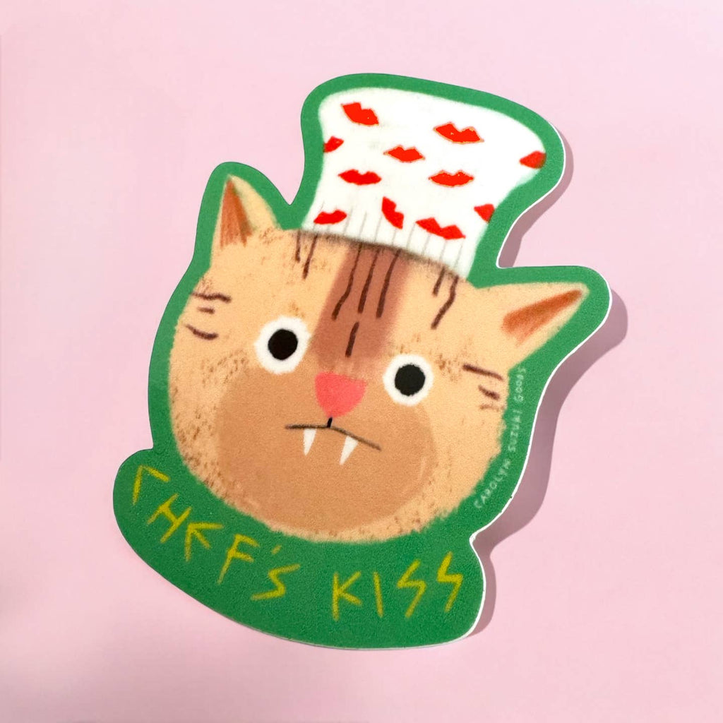 Decorative sticker with image of a brown cat wearing a white chef's hat with red lips on it and yellow text says, "Chef's kiss". 