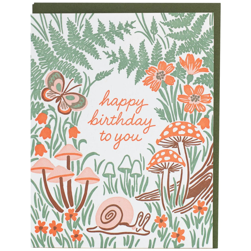 Ivory background with image of brown and peach snail surrouned by green ferns and orange flowers with orange text says, “happy birthday to you”. Green envelope included.