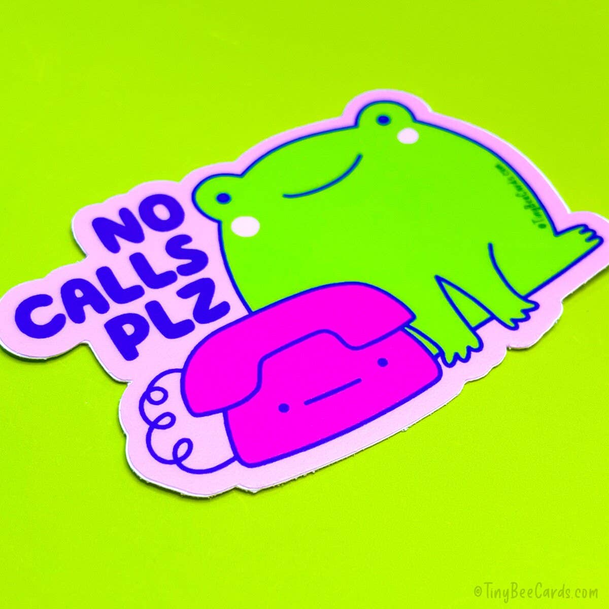 Image of sticker with pink background and image of green frog and hot pink telephone with blue text says, "No calls plz". 