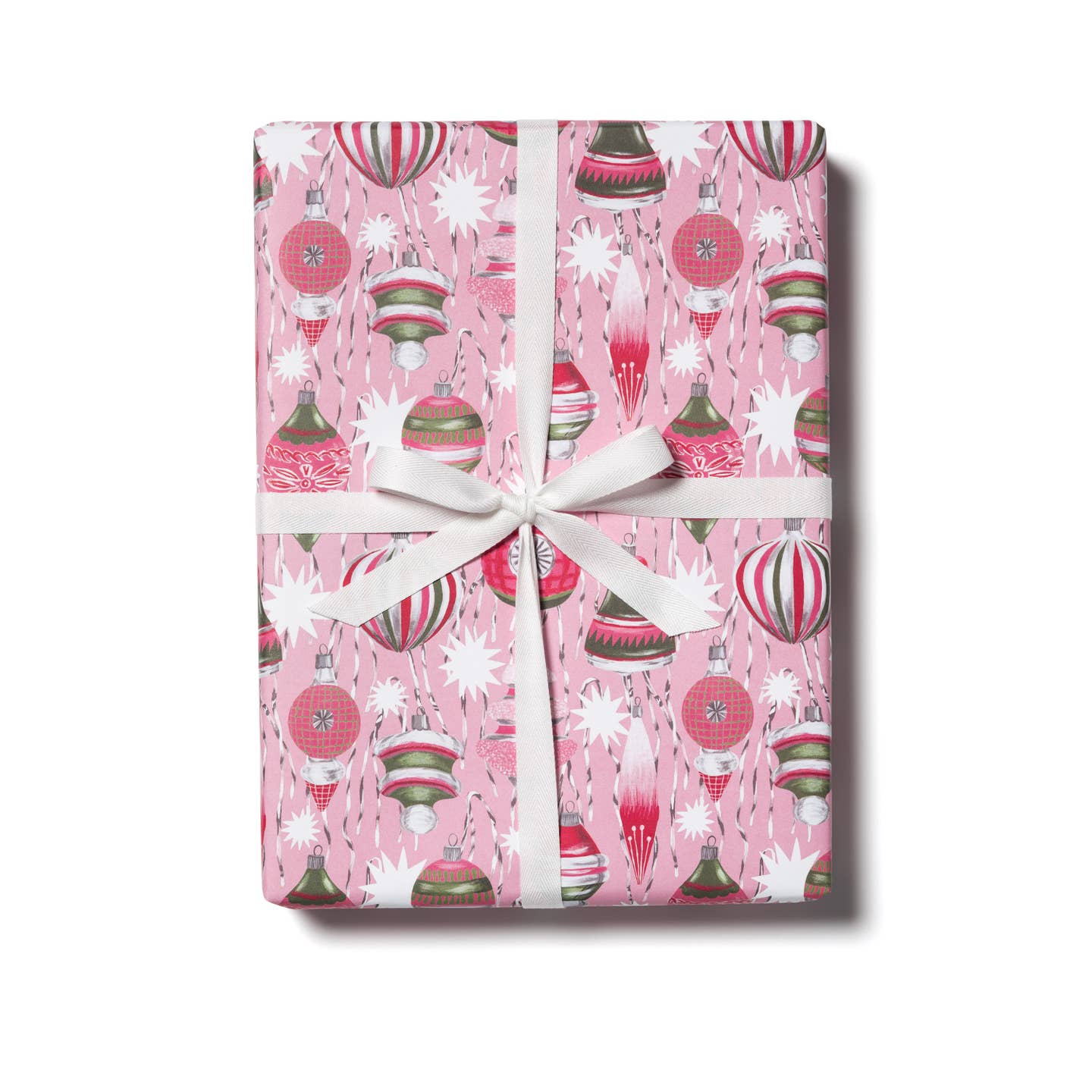 Wrapping paper with pink background and images of retro ornaments in white, pink and green. 