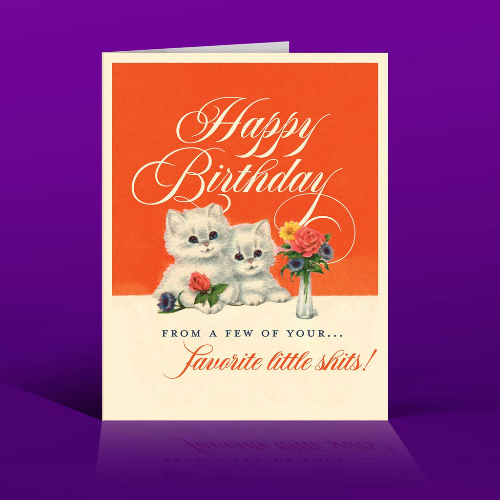 Greeting card with red and white background and an image of two white kittens holding flowers with white text says, "Happy Birthday" and black text says, "From a few of your ..." and red text says, "favorite little shits!". Envelope included.