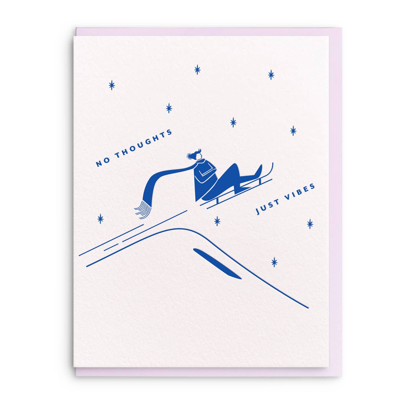 Greeting card with white background and image of person riding on a sled in blue ink and text says, "No thoughts, just vibes". Lilac envelope included.