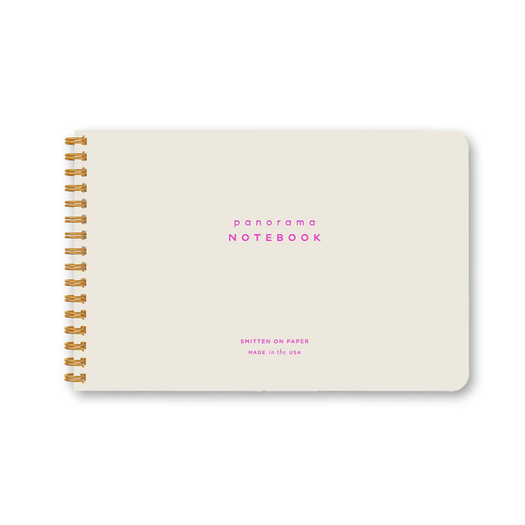 Notebook with white background and pink text says, "Panorama notebook,Smitten on paper, Made in the USA". Gold coil binding on side. 