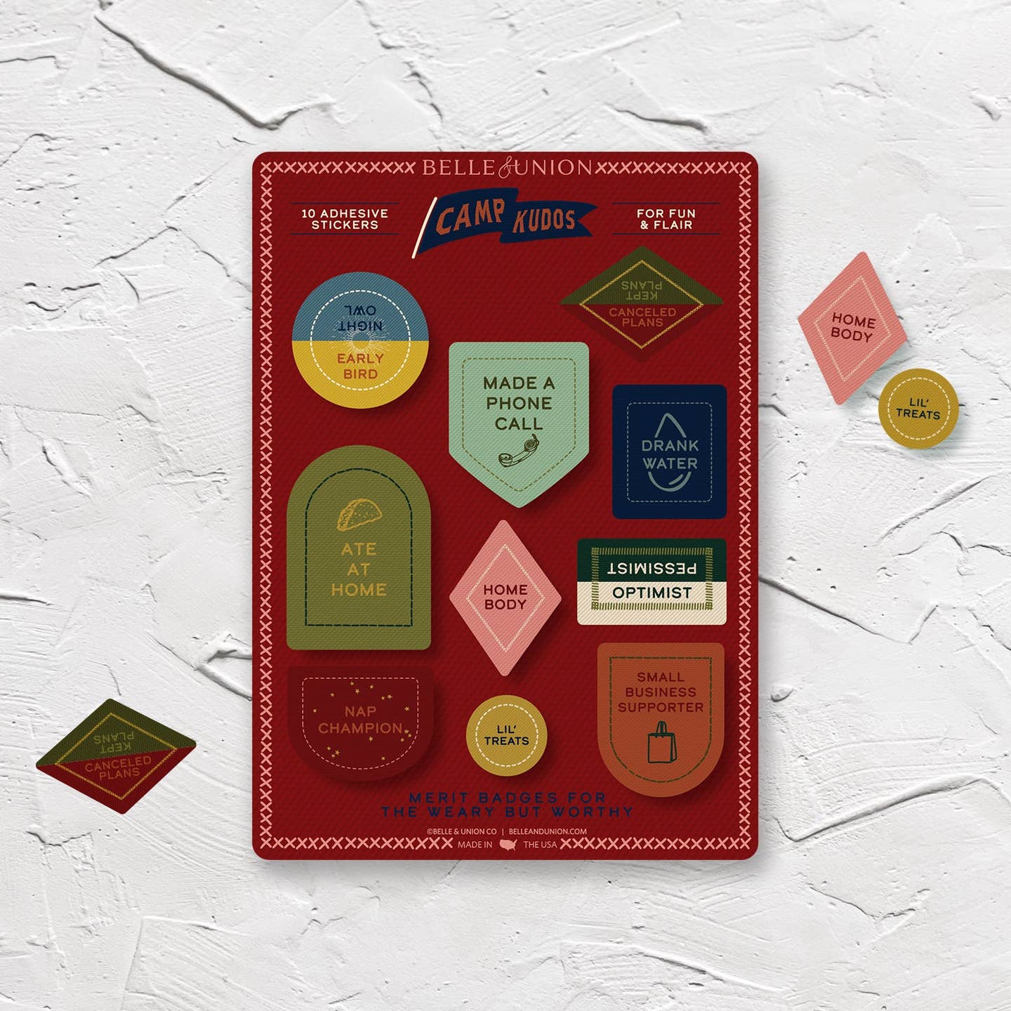 Sticker sheet with burgundy background and stickers with adult merit badges including "made a phone call, Home body, Drank water, Lil' treats".