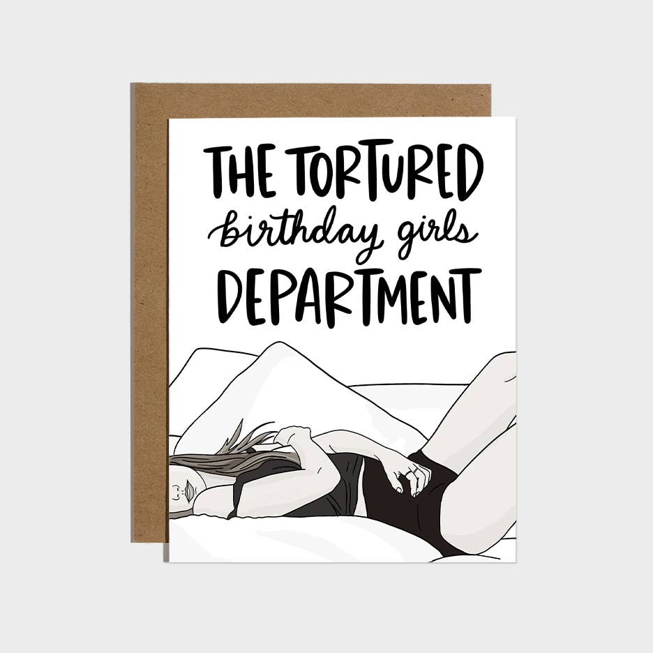 Greeting card with white background and image of Taylor Swift lying on a couch and black text says, "The tortured birthday girls department". Kraft envelope included.