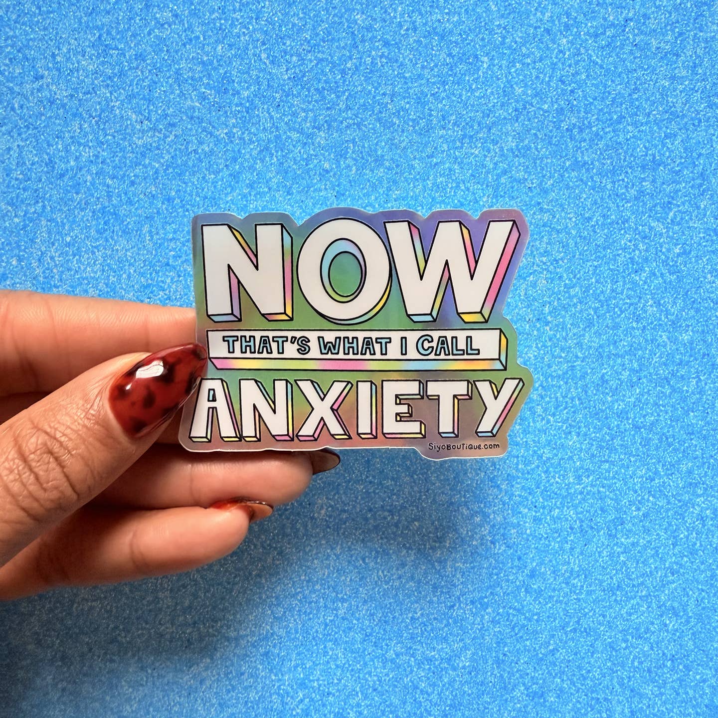 Decorative sticker with iridescent details and white text says,"Now that's what I call anxiety". 