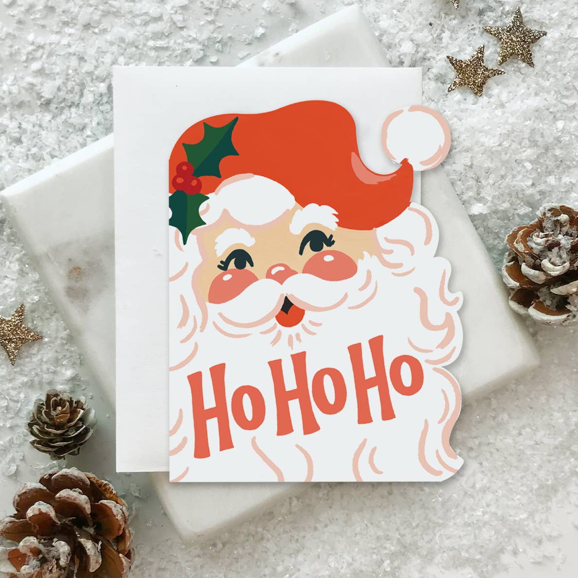 Greeting card with image of Santa Claus head with red text says, "Ho Ho Ho". Envelope included.