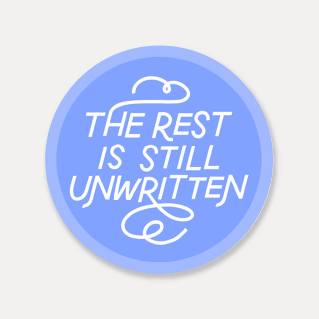 Decorative sticker with blue background and white text says, "The rest is still unwritten". 