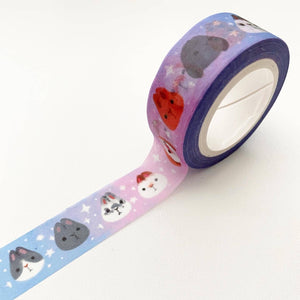 Image of roll of tape with blue and pink ombre background with images of bunnies in grey, white and  orange  with white sparkles. 