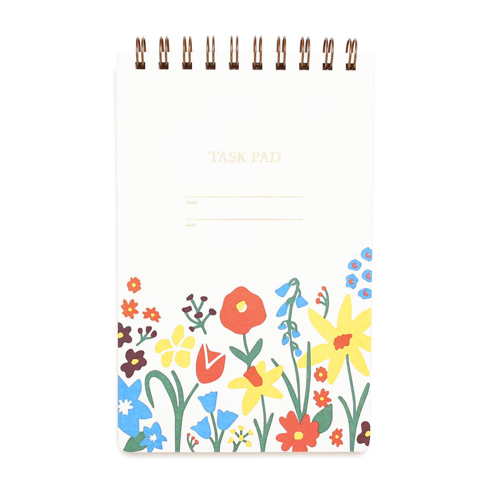 White background with garden flowers at bottom in red, orange, yellow, and green with coiled binding at top and embossed text says, “Task Pad”, “Name”, and “Date”. 
