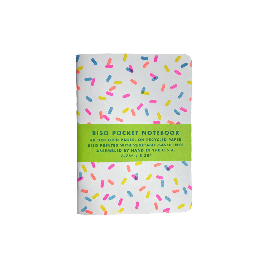 Notebook with white background and neon sprinkles.