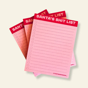 Notepad with pink lined paper with checkboxes and red header with pink text says, "Santa's Shit List". 