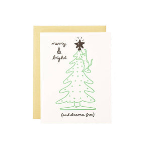 Greeting card with white background with image of a green Christmas tree with a cat climbing it and going to hit the star with its paw. Black text says, "Merry & bright, (and drama free). Envelope included. 