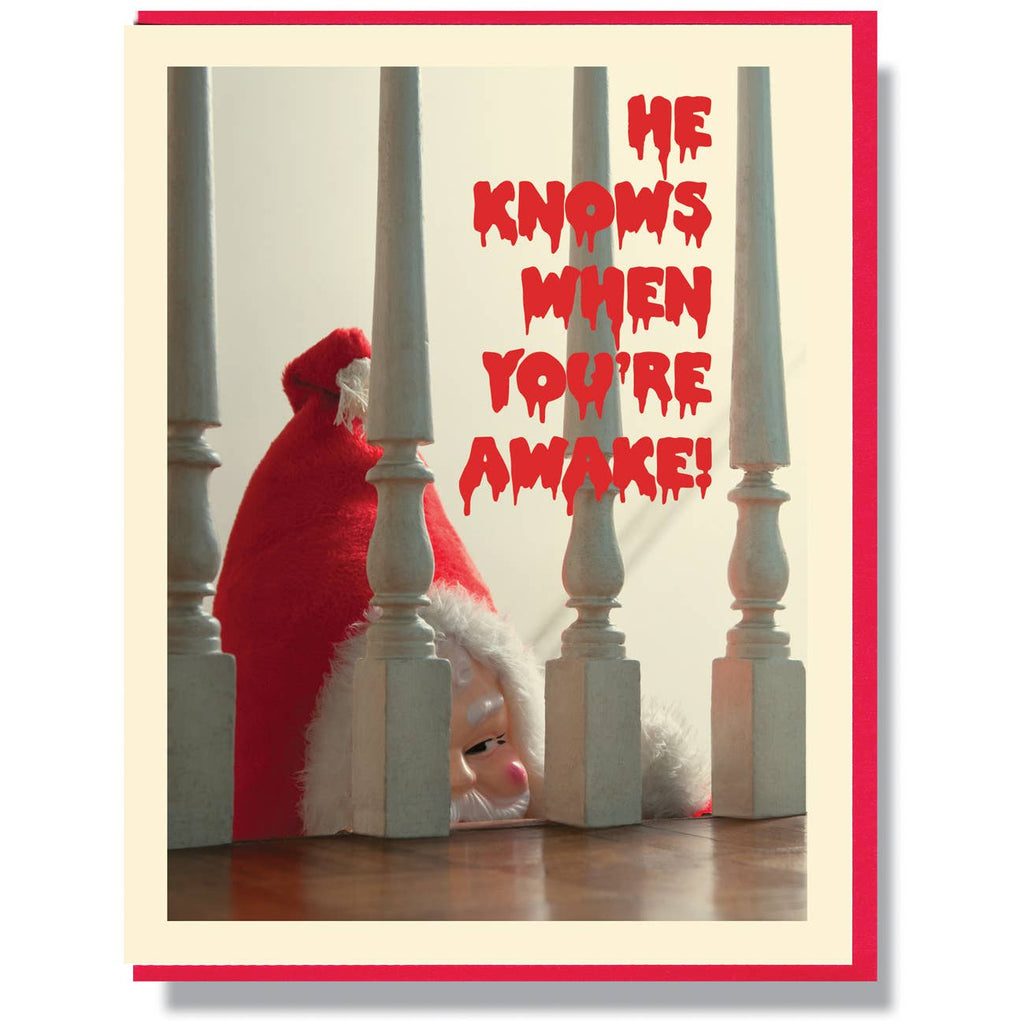 Greeting card with white background and image of creep Santa peering from behind and red creepy text says, "He knows when you're awake!". Red envelope included. 