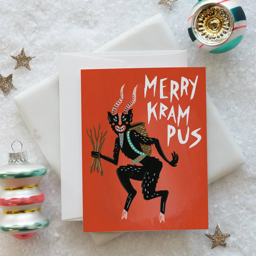 Greeting card with red background and image of Krampus with white text says, "Merry Krampus". Envelope included.