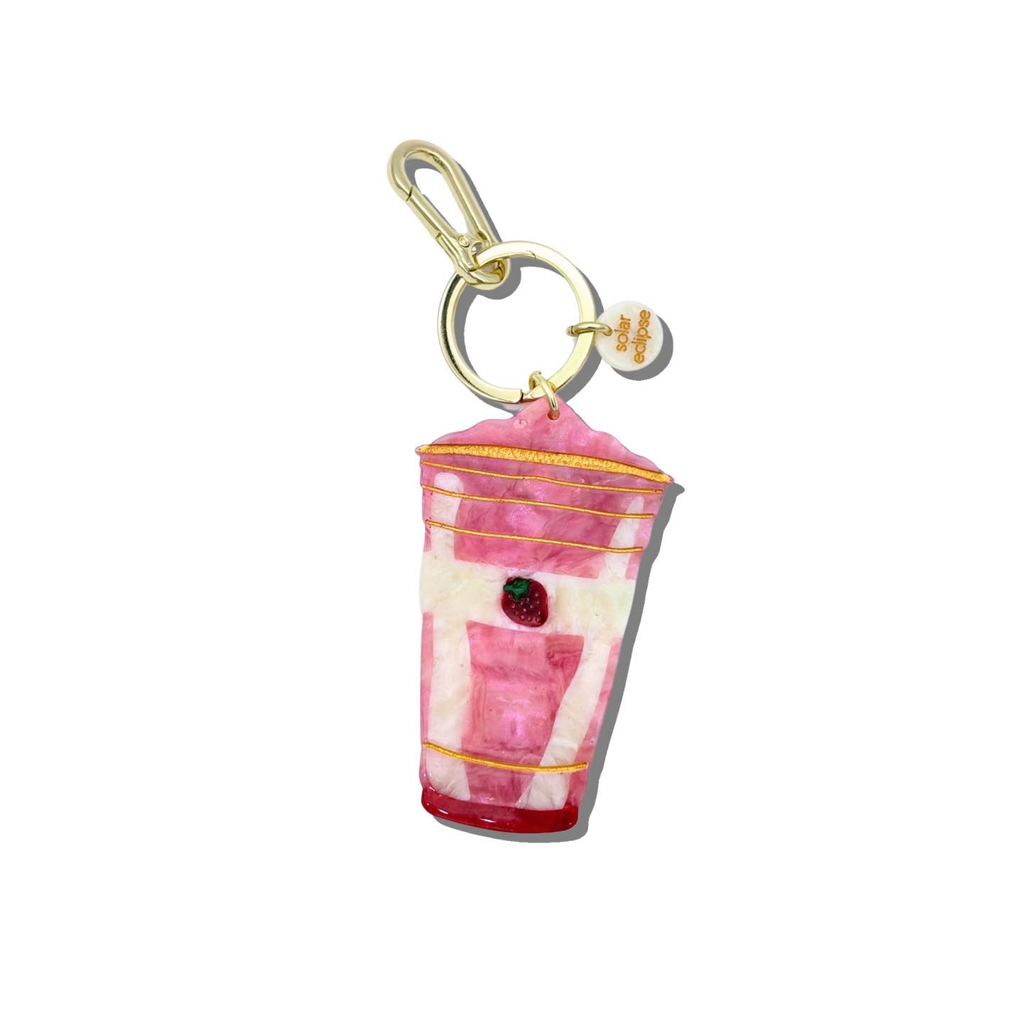 Image of key chain charm in the image of a strawberry smoothie in pink and white with picture of strawberry on the cup. Gold colored ring and clip. 