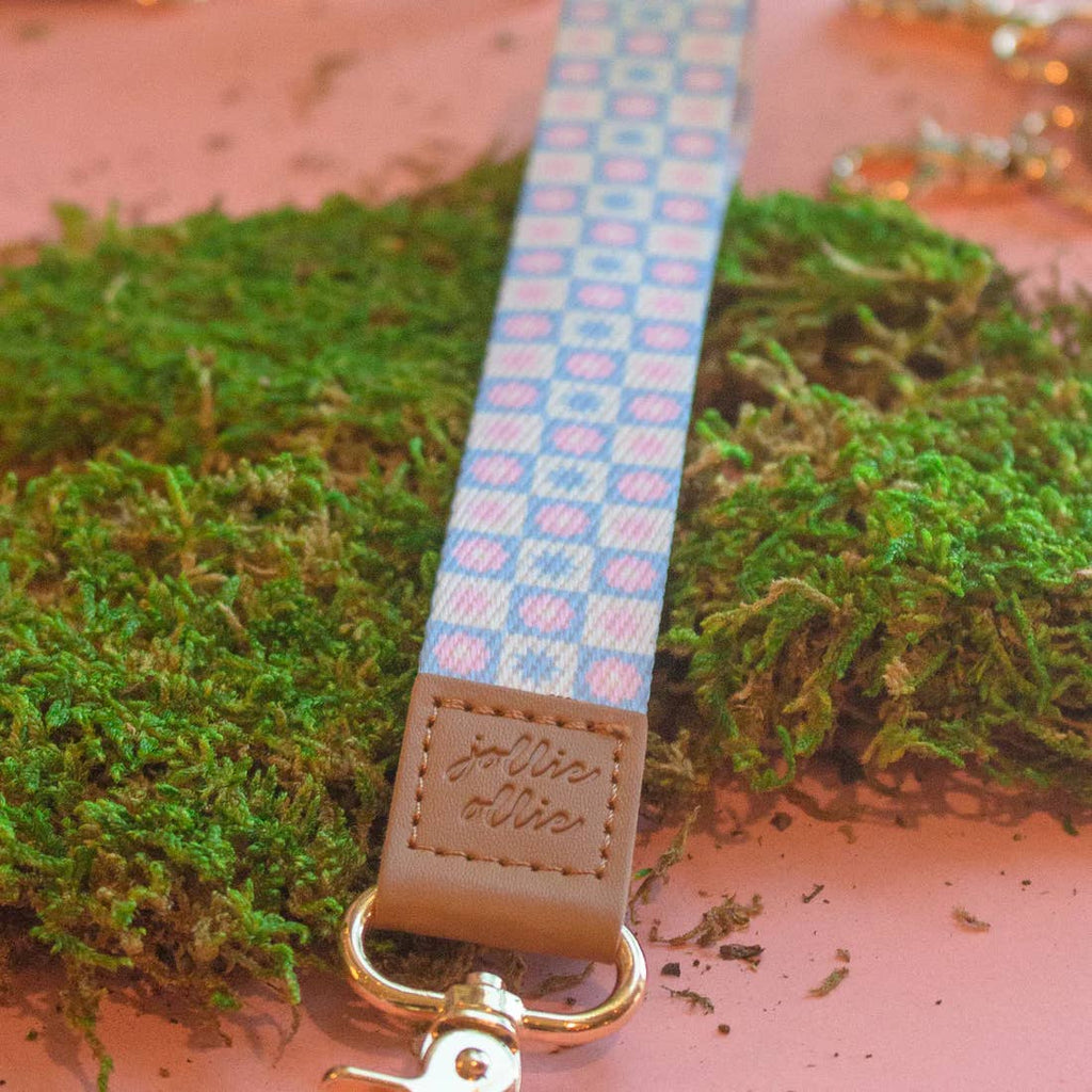 Blue and white checkerboard background with pink flowers and leather end with gold clip.