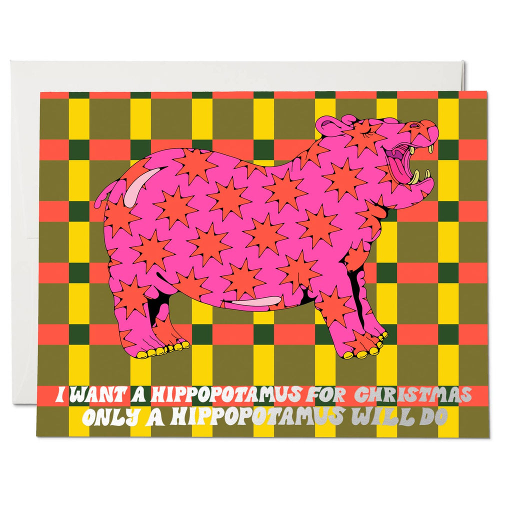 Green, yellow and red checkerboard background with image of hot pink hippo with red stars. White text says, "I want a hippopotamus for Christmas only a hippopotamus will do". White envelope is included, 