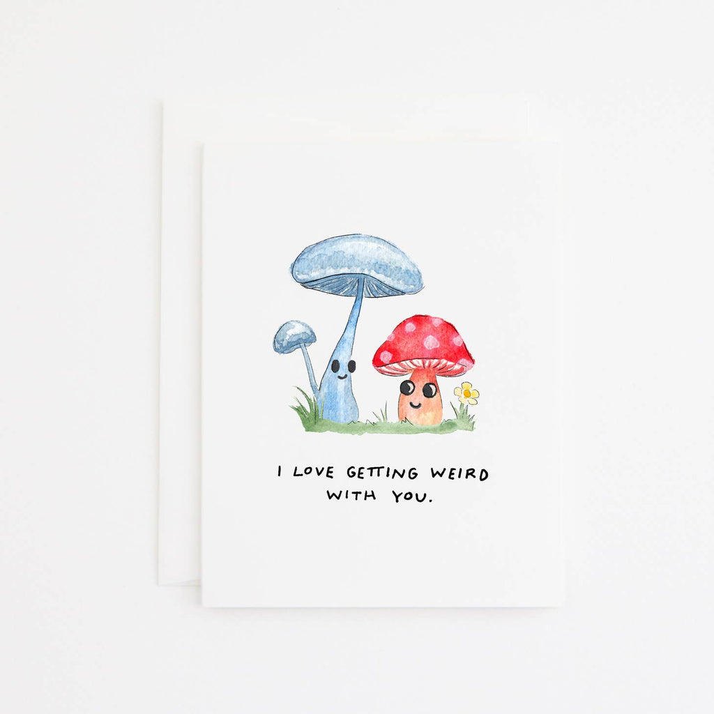 Greeting card with white background with images of two mushrooms and black text says, "I love getting weird with you." White envelope included.