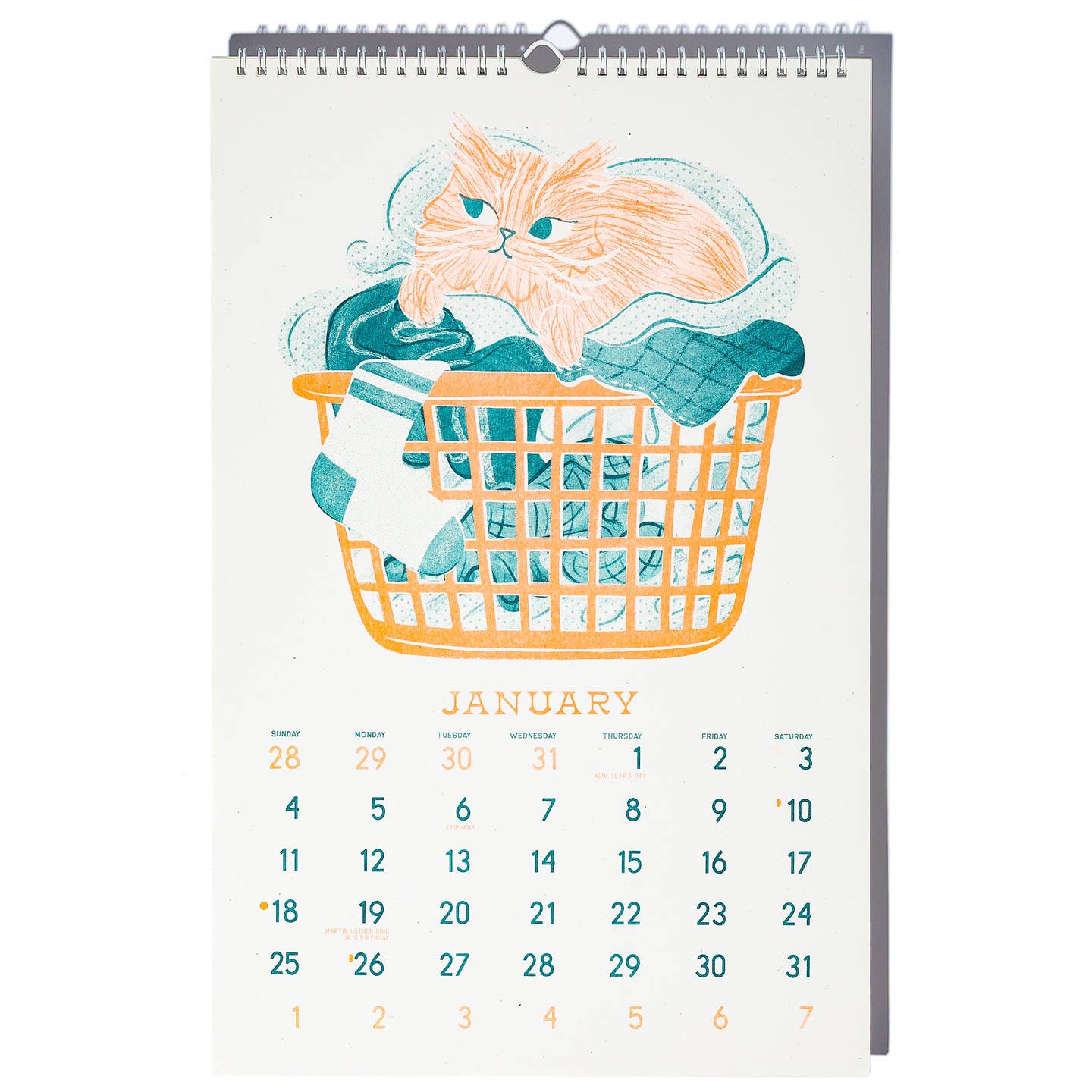 January calendar page with image of a yellow cat lying in an orange laundry basket filled with teal clothing.