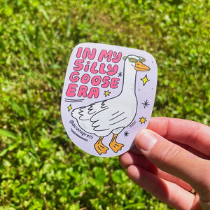 Sticker with lilac background and image of a white goose wearing sunglasses and pink text says, "In my silly goose era". 