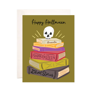 Greeting card with olive green background with stack of books with skull on top. Black text says, "Happy Halloween". Books have black text says, "Dracula, Frankenstein, Ghost stories". Envelope included. 