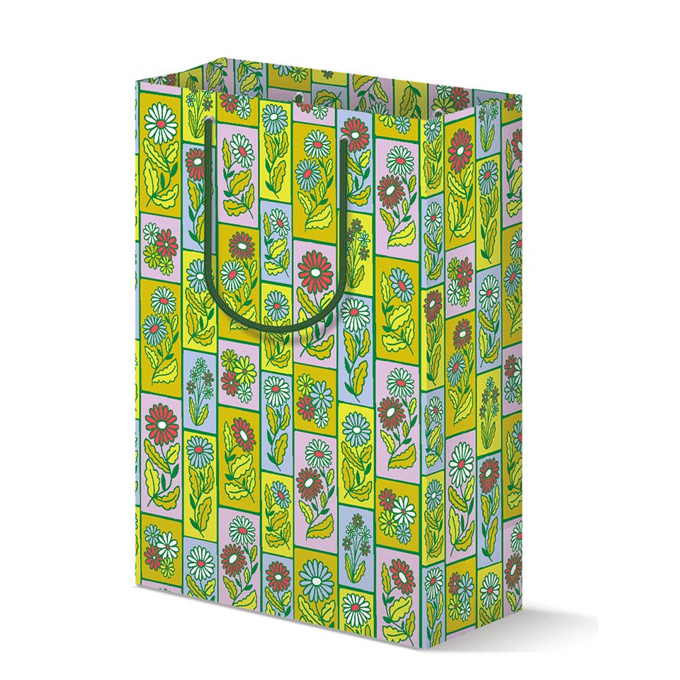 Gift bag with grid of boxes  and images of daisies in white, red and neon green. Green handles.