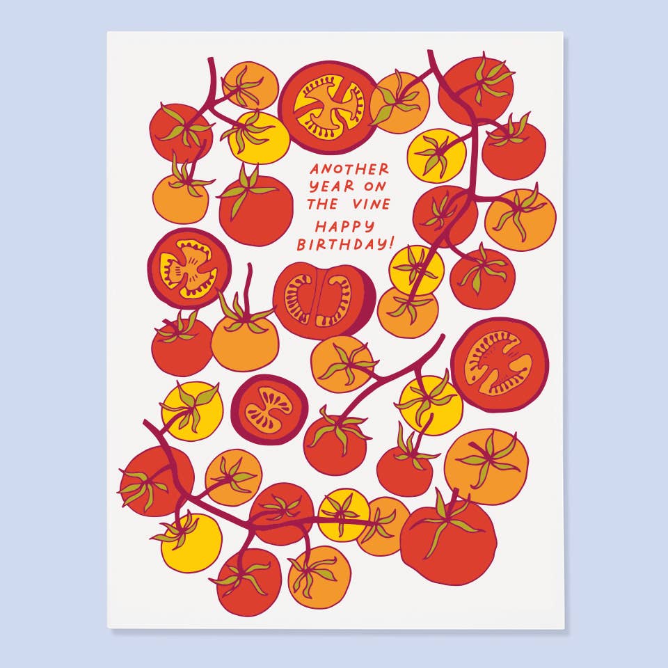 Greeting card with white background and images of orange, yellow and red tomatoes on vines and red text says, "Another year on the vine, Happy Birthday!". Envelope included.