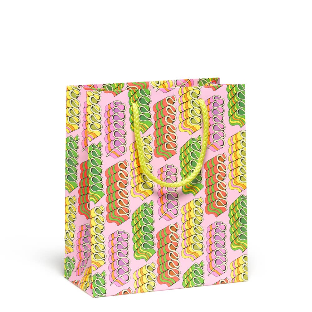 Gift bag with pink background and images of candy ribbons in green, yellow, orange and pink with yellow cord handle. 