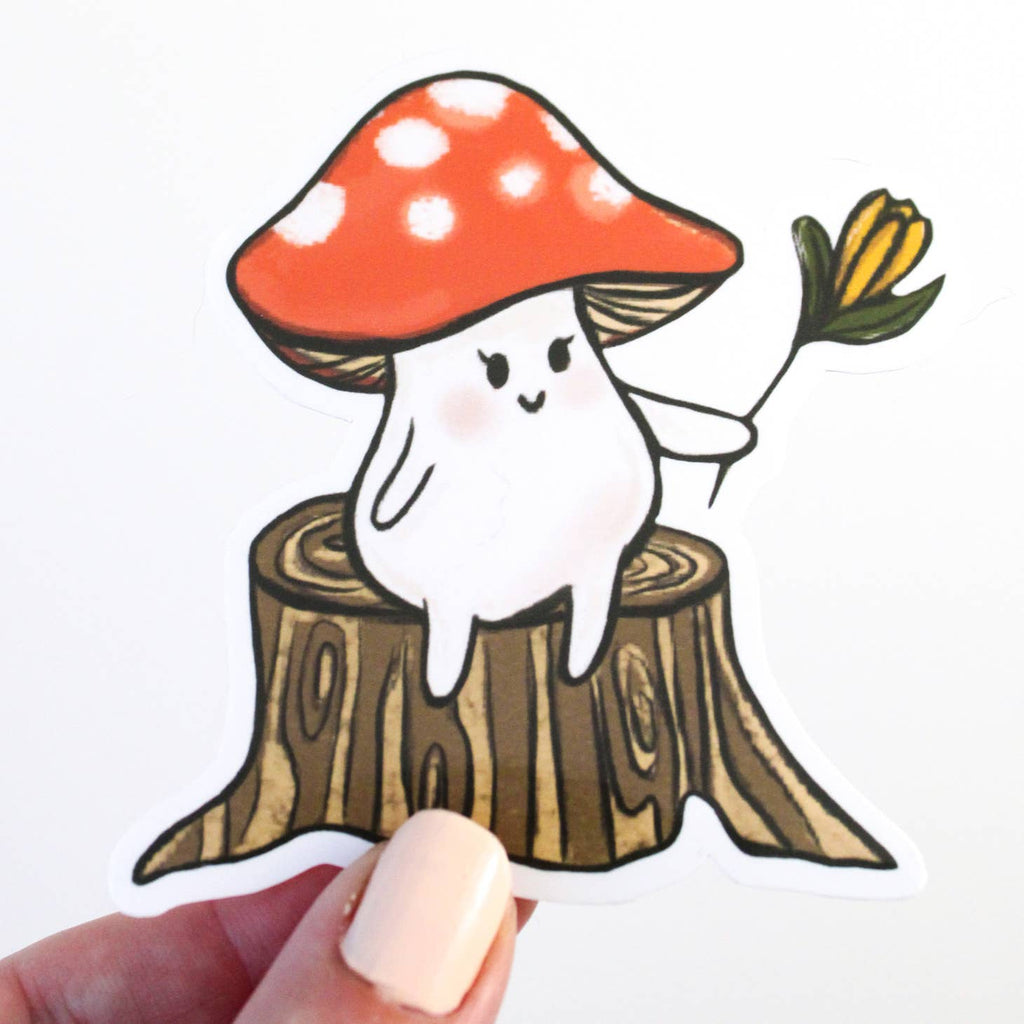 Image of white mushroom with a red polka dotted cap holding a yellow flower and sitting on a brown tree stump. 
