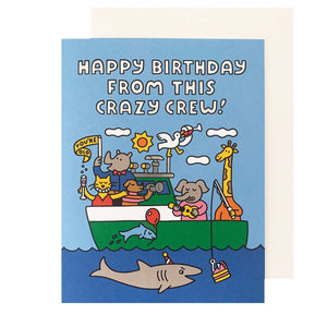 Greeting card with image of a boat filled with animals partying and wearing party hats, drinking wine and having cake. White text says, "Happy Birthday from this crazy crew!". White envelope included. 