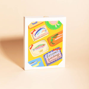 Boxed set of greeting cards with yellow background and images of canned fish with black text says, "Season's greetings". Envelopes included. 