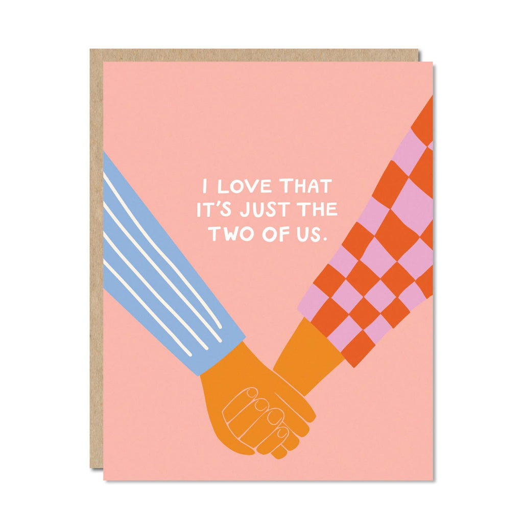 Pink background with image of two arms and holding hands with white text says, “I love that it’s just the two of us.” Kraft envelope is included.     