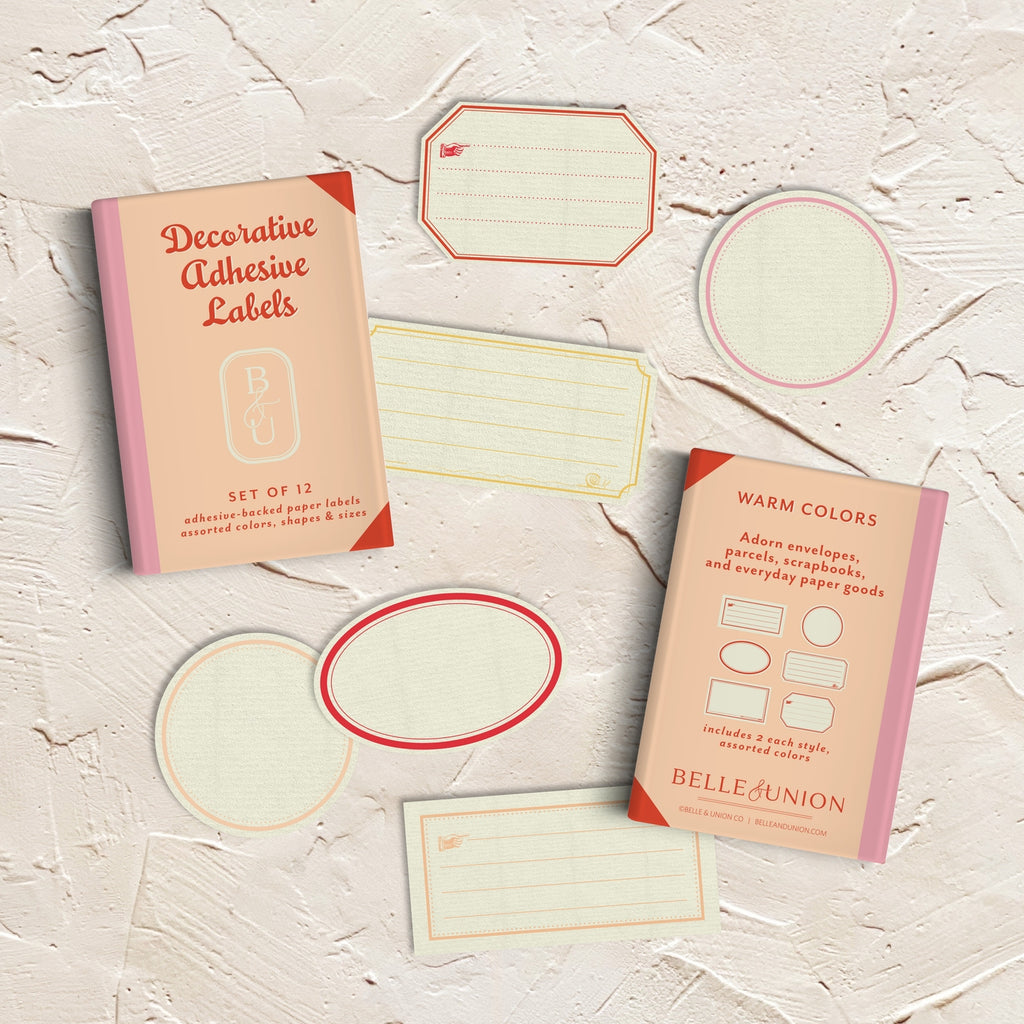 Decorative labels and box with cream background and borders in pink, red, peach and yellow.