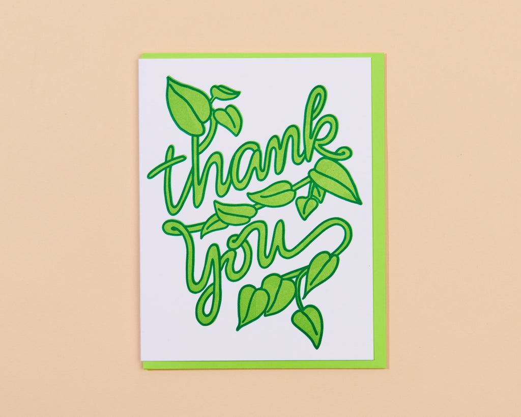 White background with image of green lettering in the form of a vine, text says, “Thank you”. Green envelope included. 