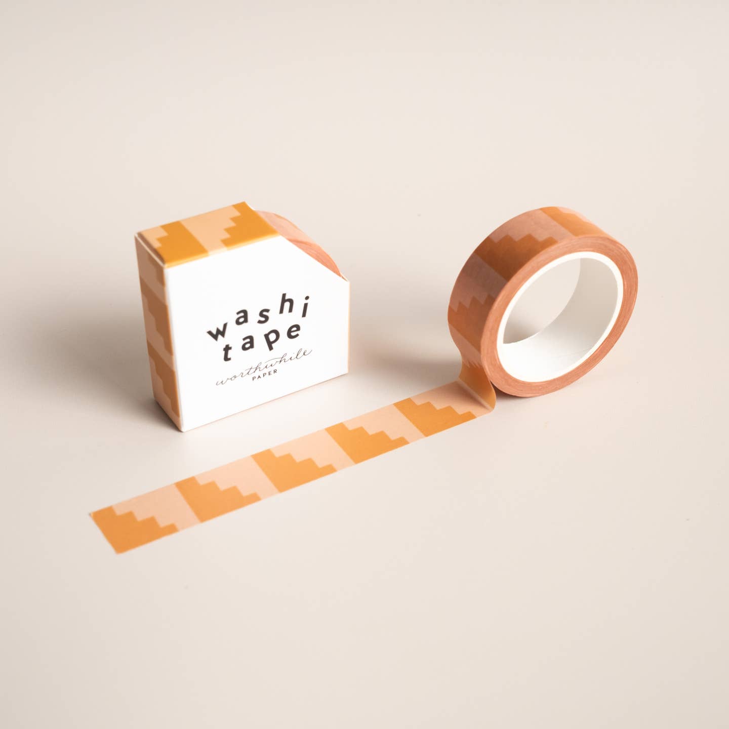 Image of roll of washi tape with beige background and orange steps repeating,