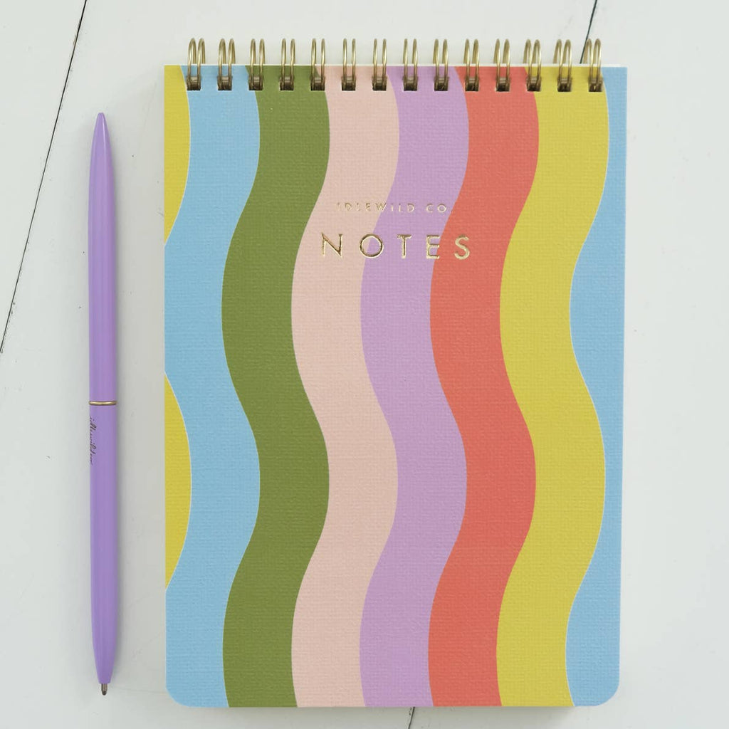 Notepad with blue, olive, pink, lilac, red, yellow and light blue vertical wavy lines with coil binding at top. 