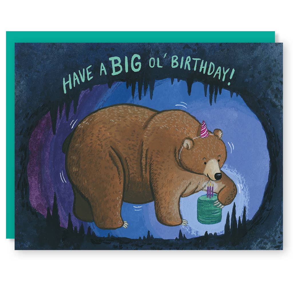 Image of a  brown bear in a cave  wearing a party hat and blowing out candles on a small green birthday cake, Green text says, "Have a big ol' birthday!". Teal envelope is included. 