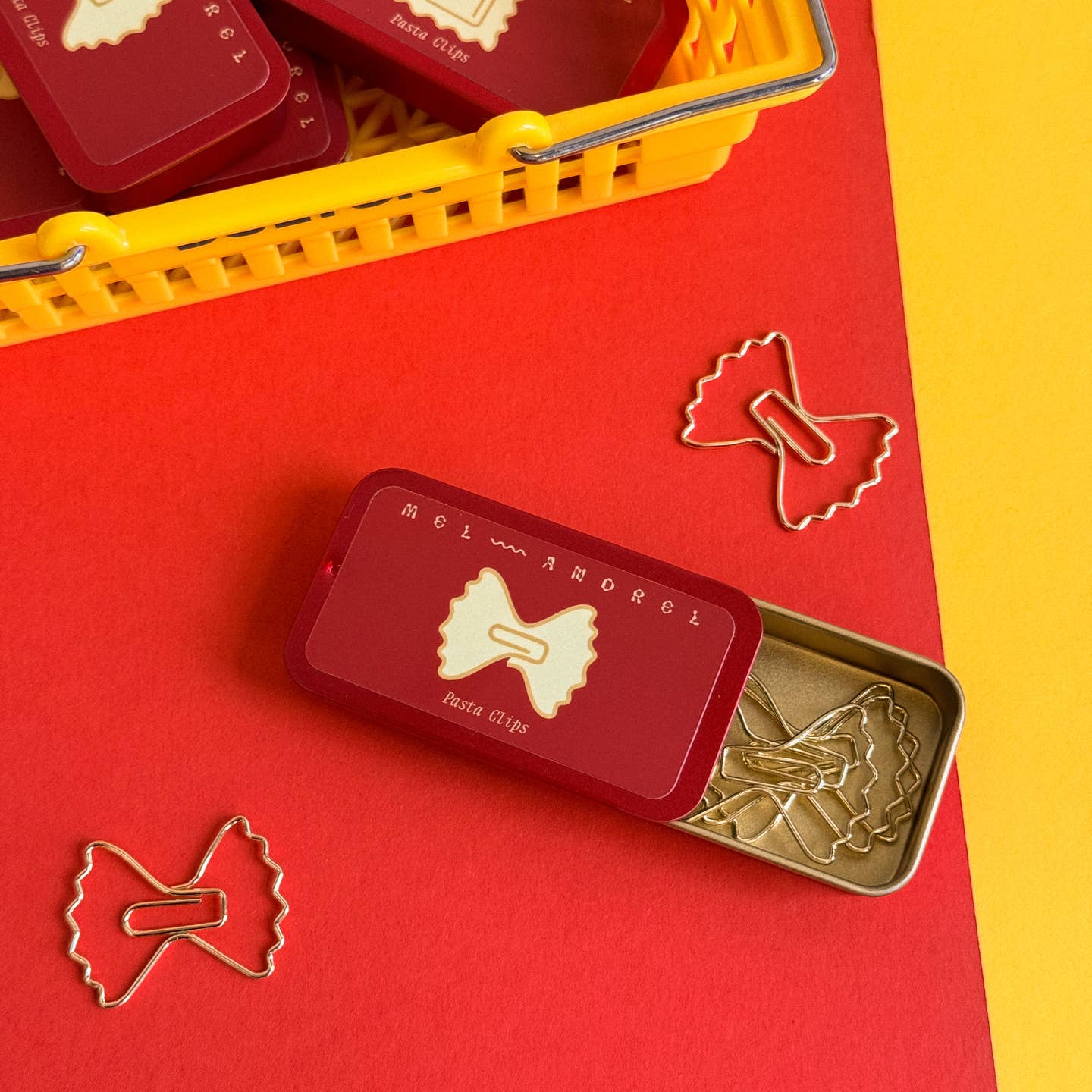 Image of a tin of paper clips shaped like bow tie pasta.